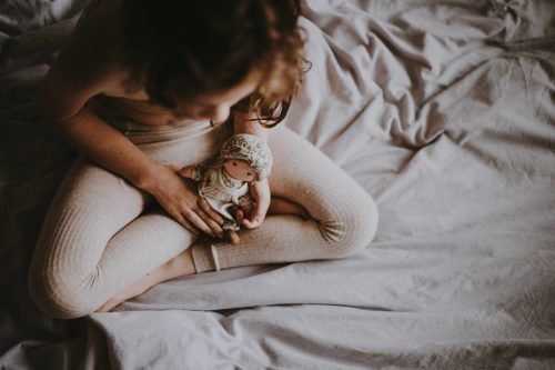 Une petite fille dans un lit avec une poupée